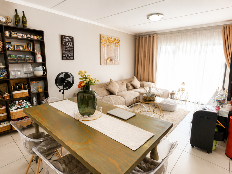 An open-plan living and dining area featuring tiled flooring and a large sliding glass door that provides ample natural light.