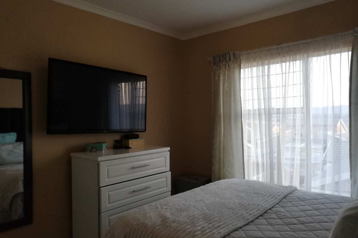 A cozy bedroom featuring a window with natural light, neutral wall tones, and space for bedroom furniture.
