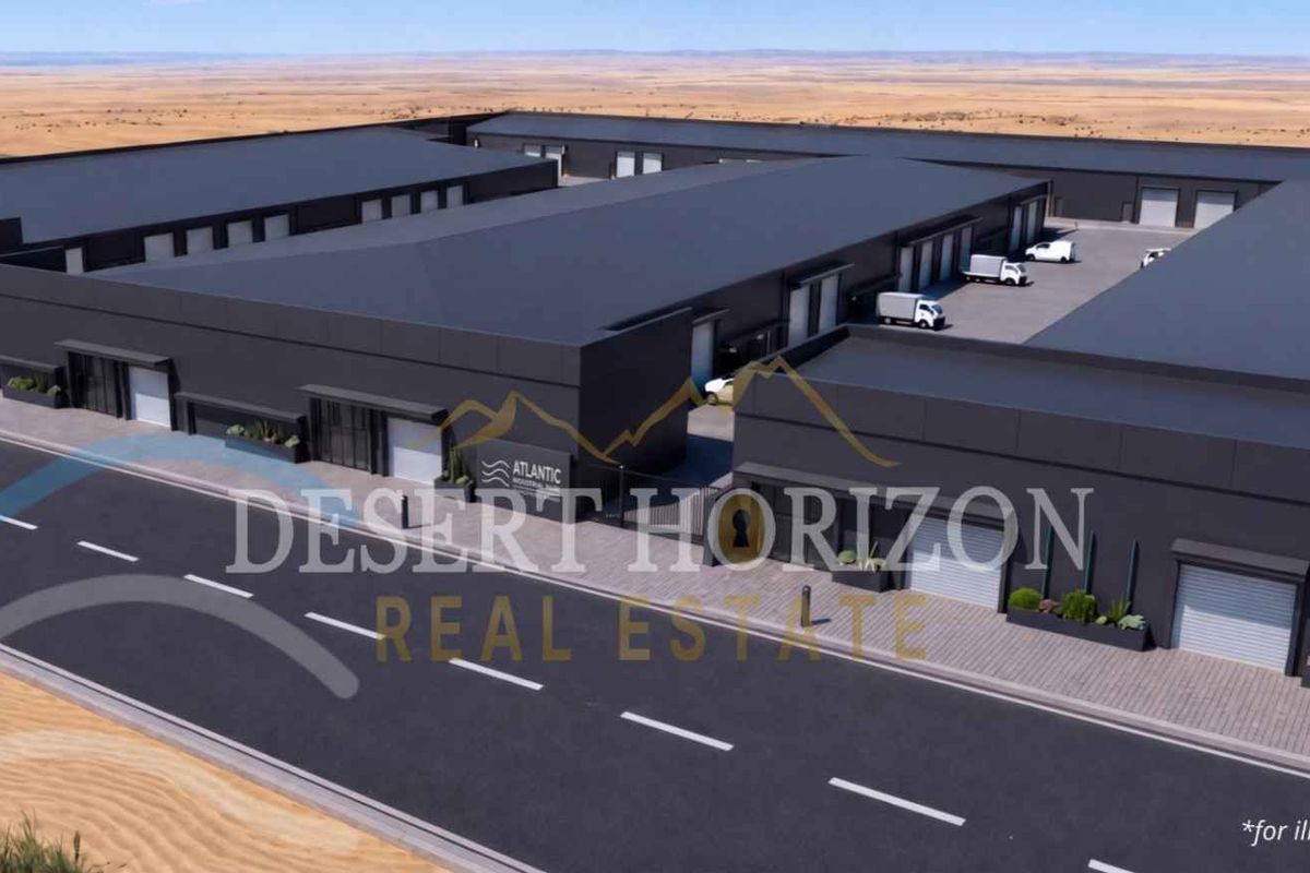 Aerial view of a modern industrial complex featuring multiple warehouse units with roller shutter doors and paved access roads.