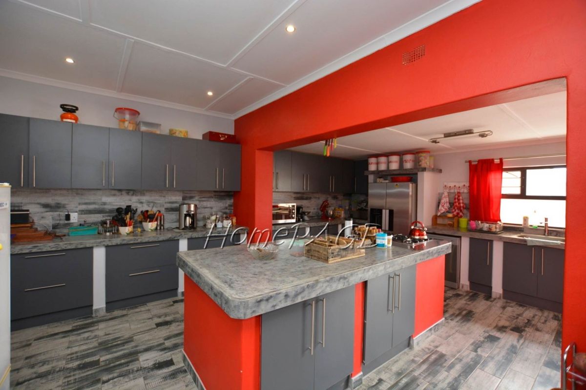 Spacious kitchen featuring a central island, grey cabinetry, stone-look countertops, and recessed ceiling lighting.