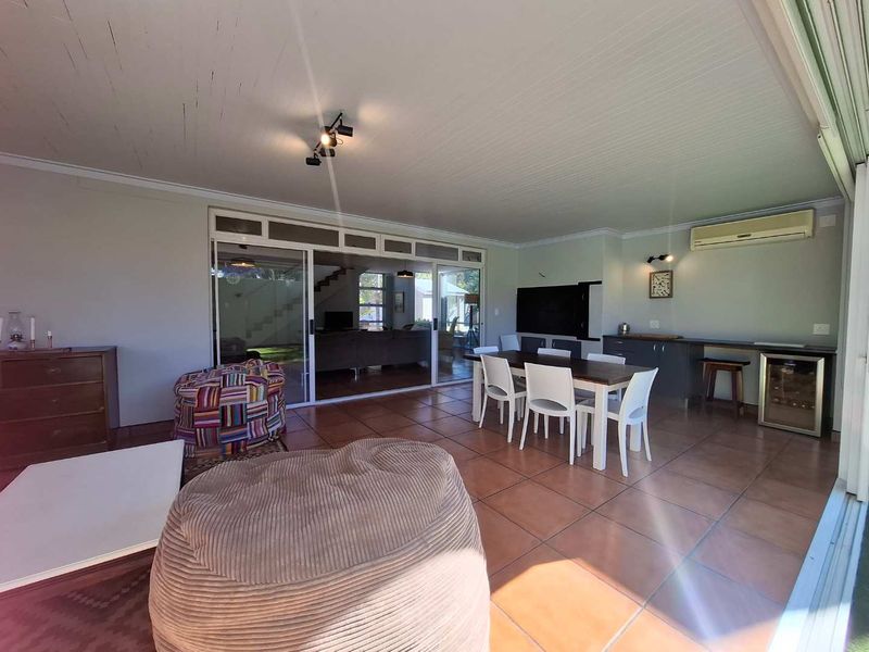Spacious open-plan living and dining area featuring tiled floors, built-in cabinetry, and large sliding glass doors providing seamless access to the outdoor space.