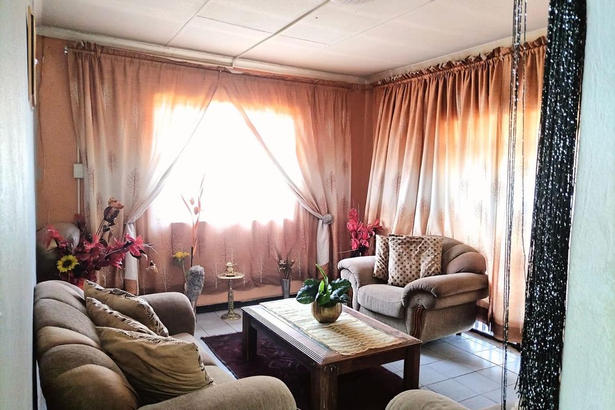 A living room featuring tiled flooring and a dated ceiling finish, offering a blank canvas for modernization and interior updates.