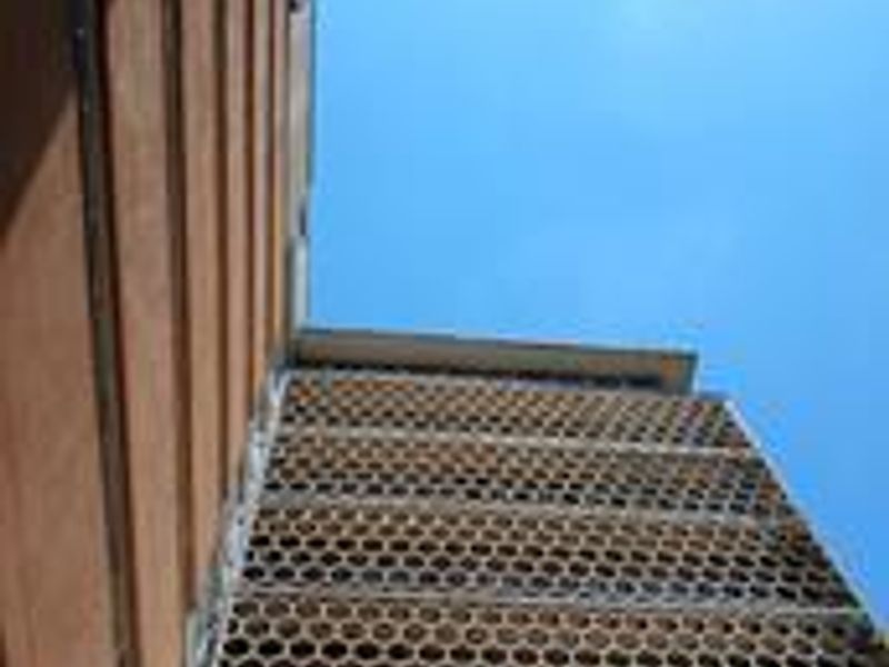Low angle view of a multi-story commercial building facade featuring a distinctive honeycomb-patterned architectural screen.