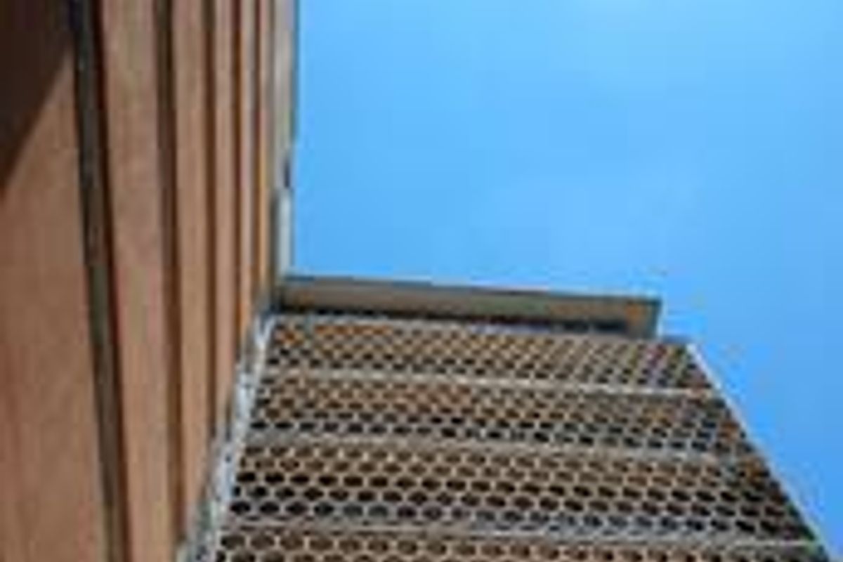 Low angle view of a multi-story commercial building facade featuring a distinctive honeycomb-patterned architectural screen.