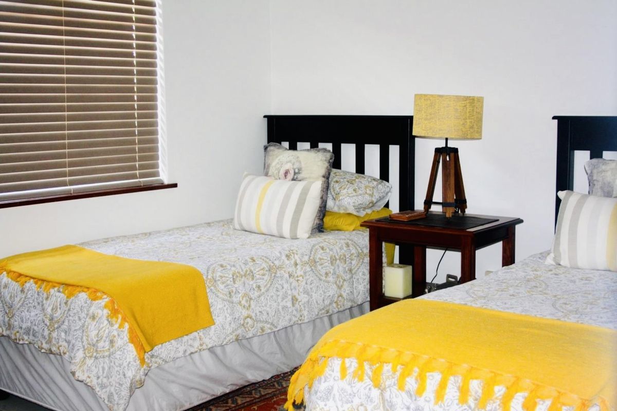 A bedroom featuring neutral walls and fitted window blinds, providing a functional and comfortable sleeping space.