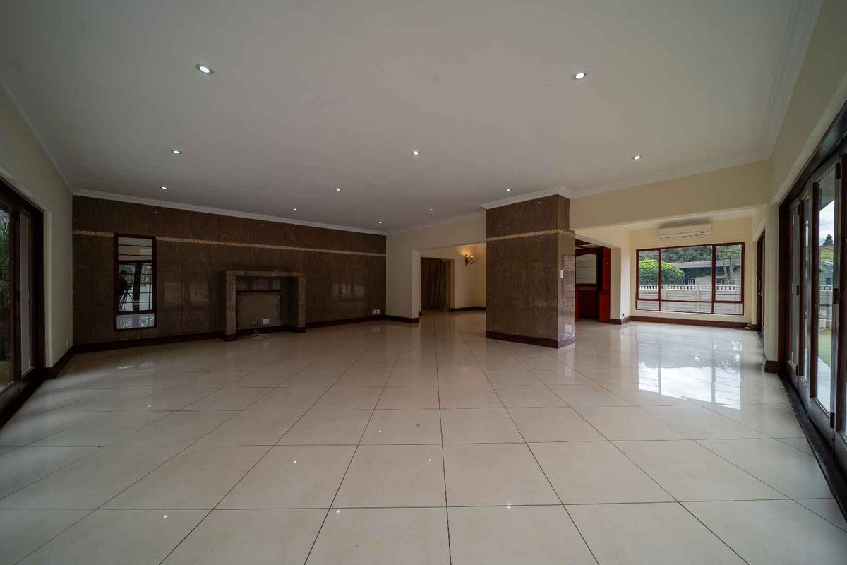 Spacious, open-plan living area featuring polished tile flooring, recessed lighting, and large sliding glass doors that provide ample natural light.