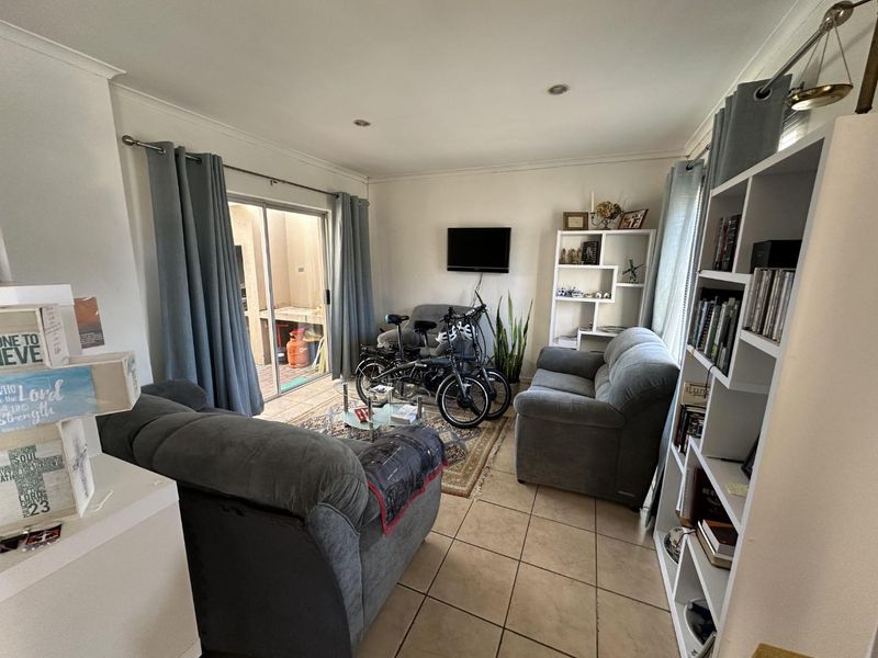 A living room featuring tiled flooring and a sliding glass door providing access to an outdoor area.