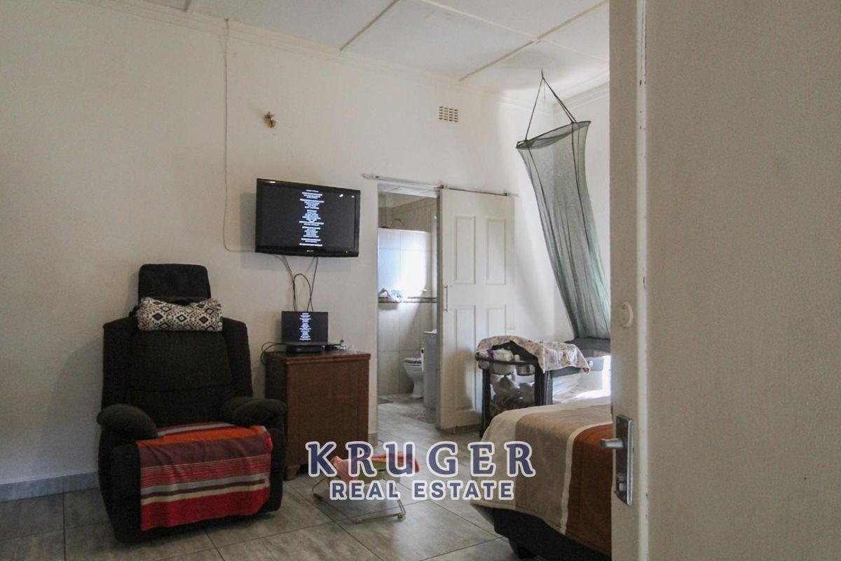 A bedroom featuring tiled flooring and an en-suite bathroom, providing a functional living space with direct access to private facilities.