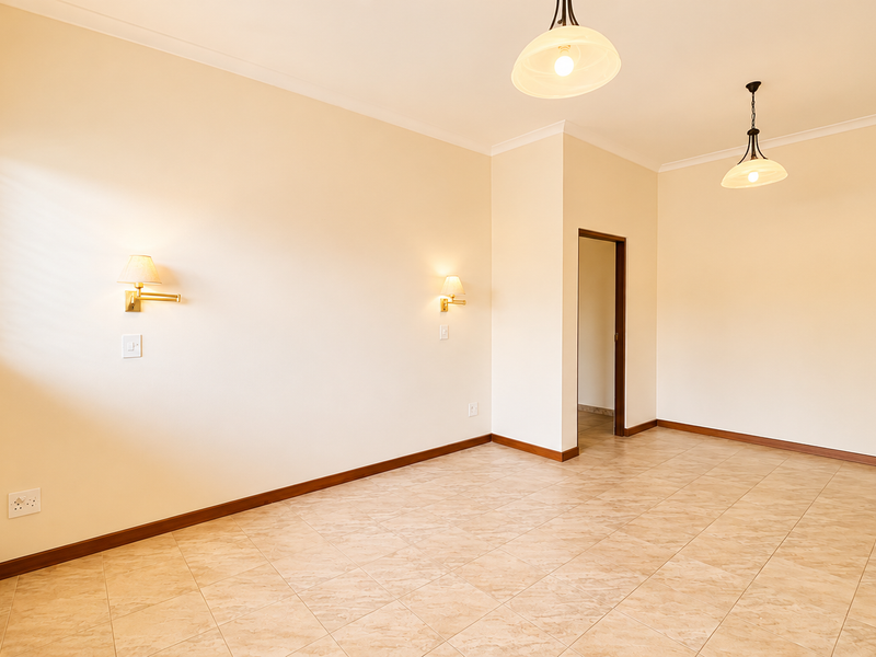 A bright, empty living room featuring neutral tiled flooring, wall-mounted sconces, pendant lighting, and large windows with venetian blinds.