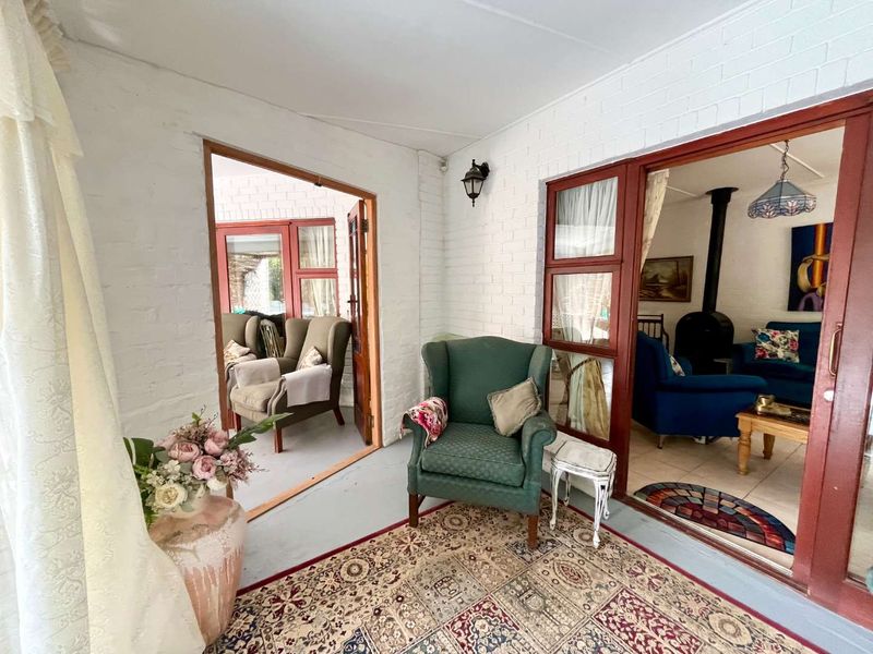A covered patio area featuring painted brick walls, concrete flooring, and sliding glass doors providing access to the interior living spaces.