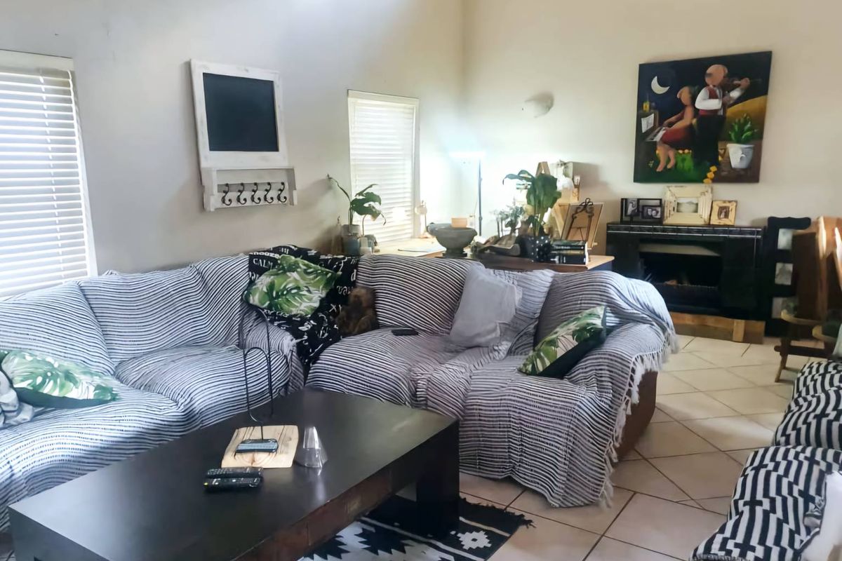 A living room featuring tiled flooring, vaulted ceilings, and a built-in fireplace, offering a comfortable and functional living space.