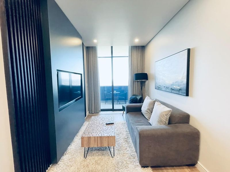 Modern living room featuring a sleek slatted feature wall with a built-in television niche and direct access to a private balcony.