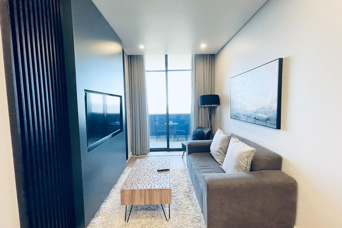 Modern living room featuring a sleek slatted feature wall with a built-in television niche and direct access to a private balcony.