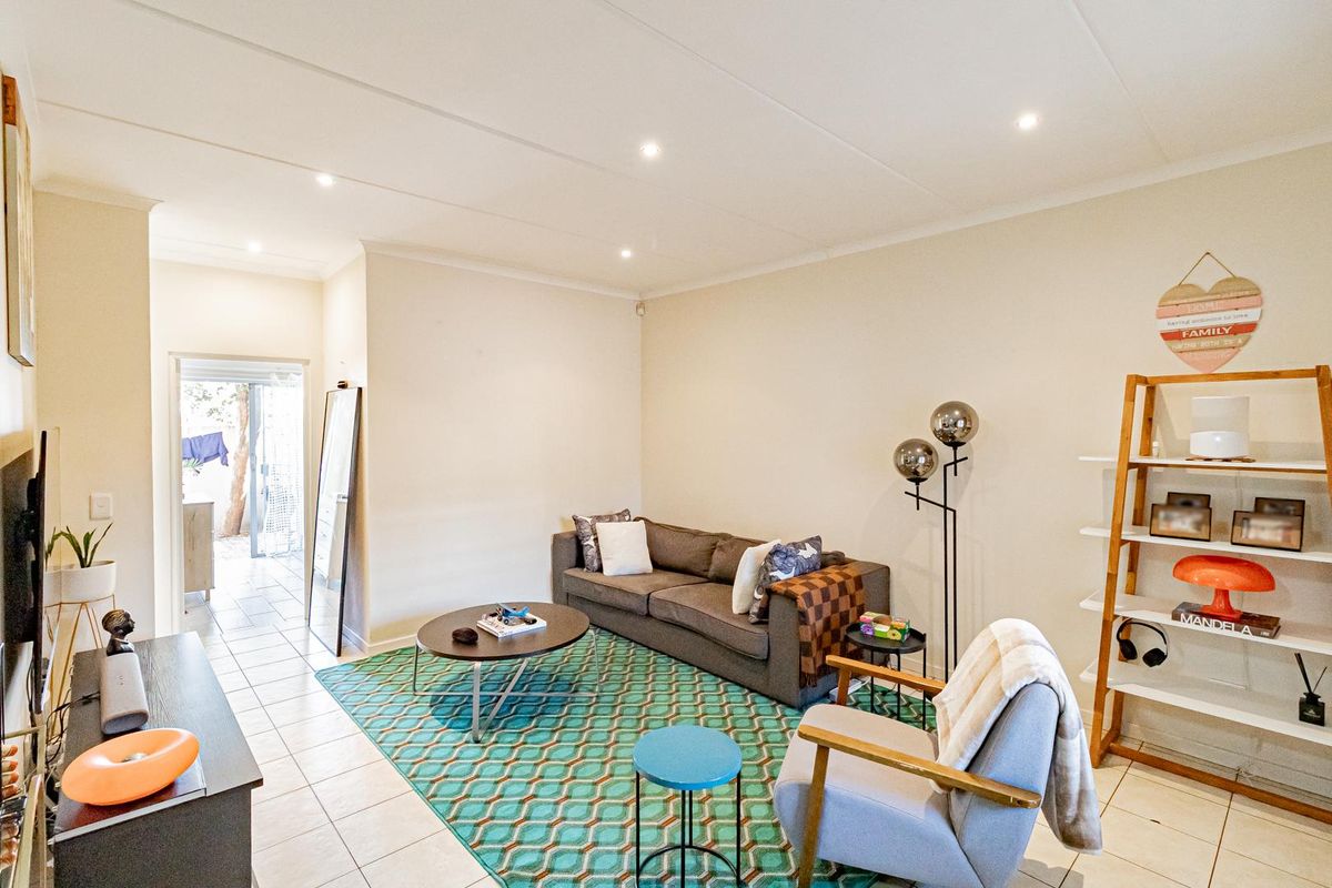 A bright and well-maintained living room featuring neutral walls, tiled flooring, and recessed downlighting, providing a comfortable and functional living space.