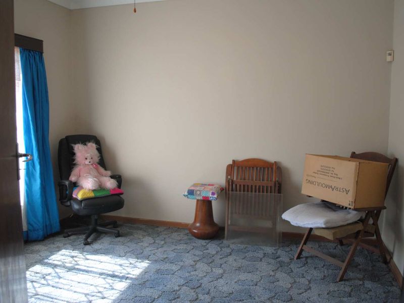 A bedroom featuring patterned carpet flooring and neutral wall paint, offering a blank canvas for potential interior updates.