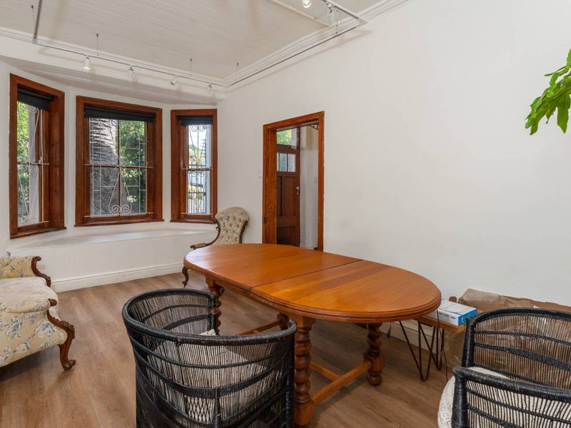 Dining room featuring a bay window with timber frames, timber flooring, and a classic beadboard ceiling with track lighting.