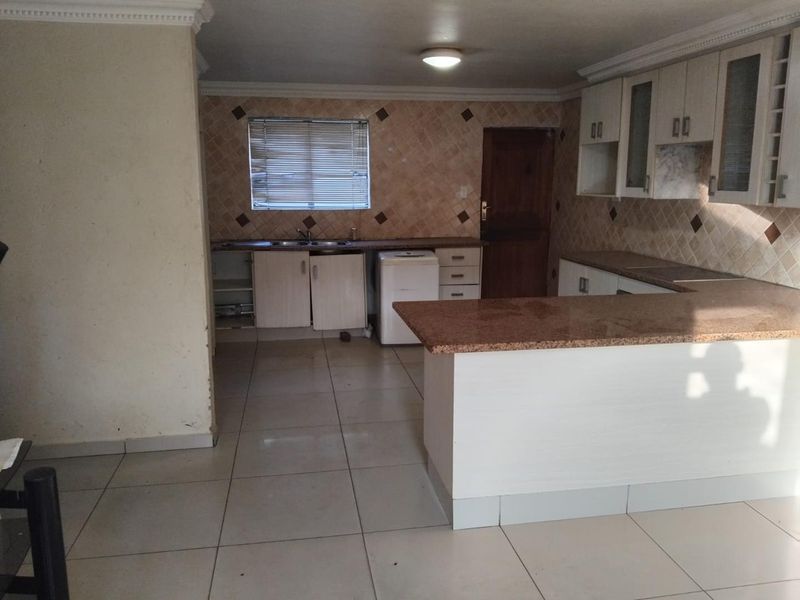 A functional kitchen featuring granite countertops, ample built-in cabinetry, a tiled backsplash, and a breakfast bar, offering a practical layout for daily use.