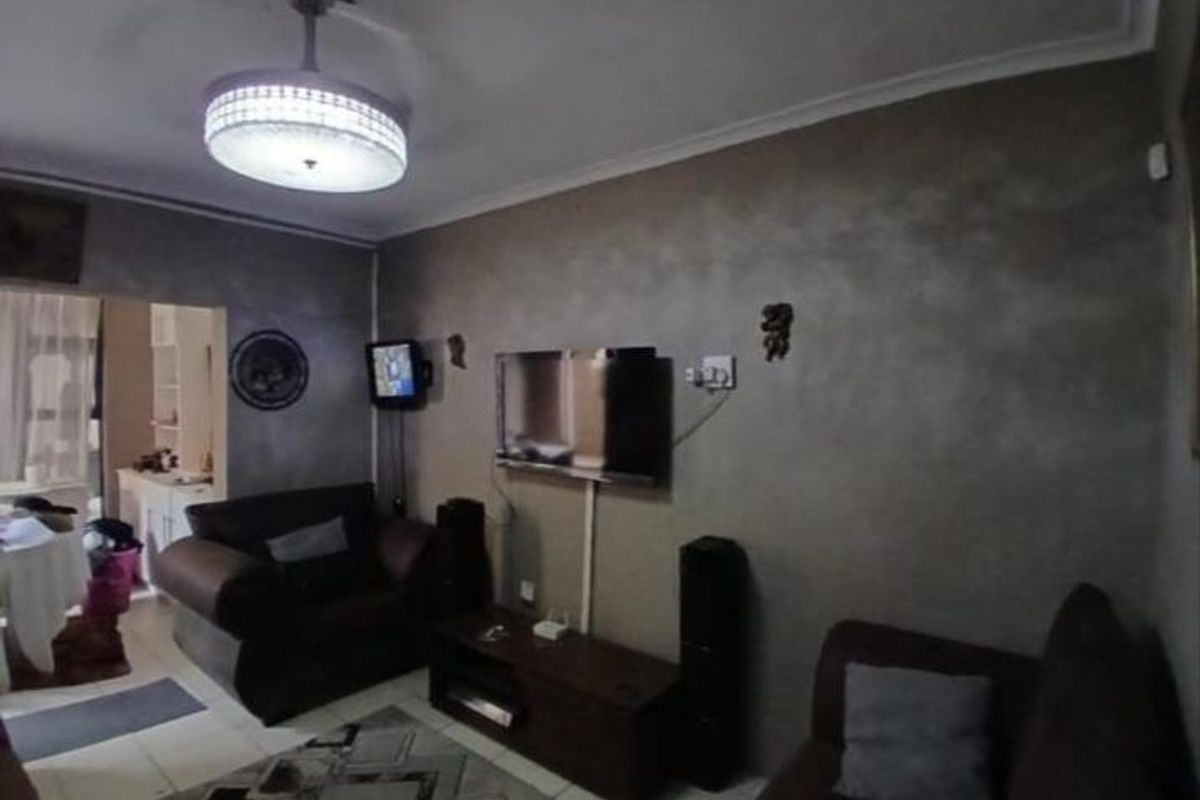 A living room featuring tiled flooring, a ceiling fan with integrated lighting, and a neutral wall finish.