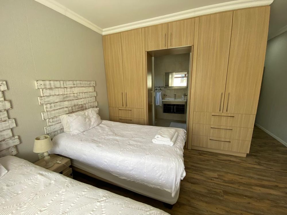 Ground floor, bedroom 3 with built-in cupboards, TV and en-suite bathroom. 