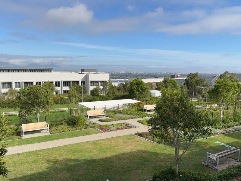 Elevated view overlooking the well-maintained landscaped gardens, paved walkways, and communal outdoor seating areas within the retirement village grounds.