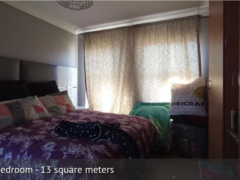 A bedroom featuring a built-in wardrobe and crown molding, offering a functional space for rest.