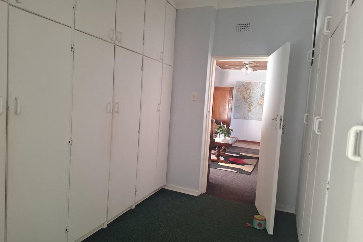 A bedroom featuring extensive floor-to-ceiling built-in cupboards, providing ample storage space and a clean, functional layout.