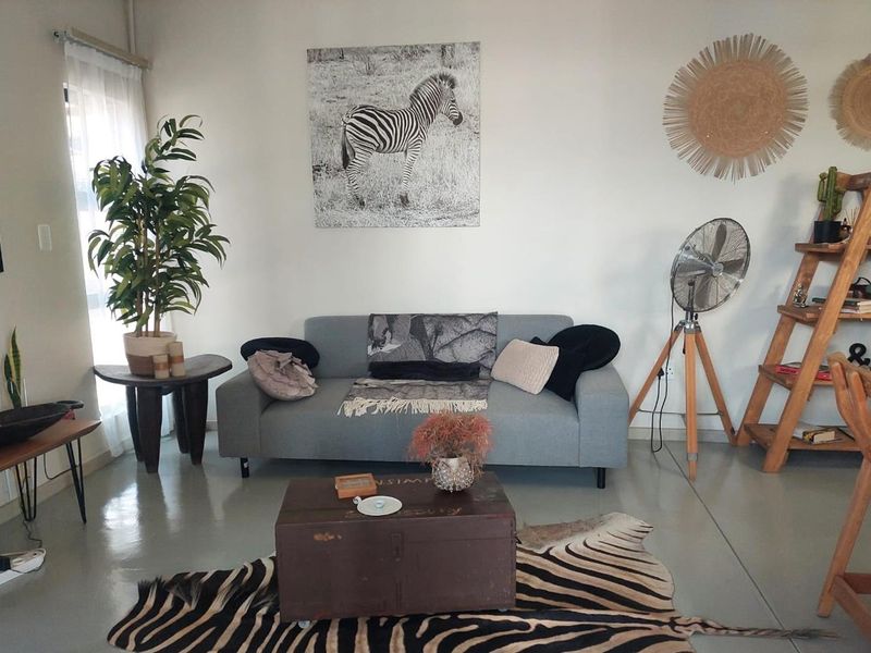 A bright living room featuring polished concrete flooring and neutral wall finishes, providing a clean and modern foundation for the space.