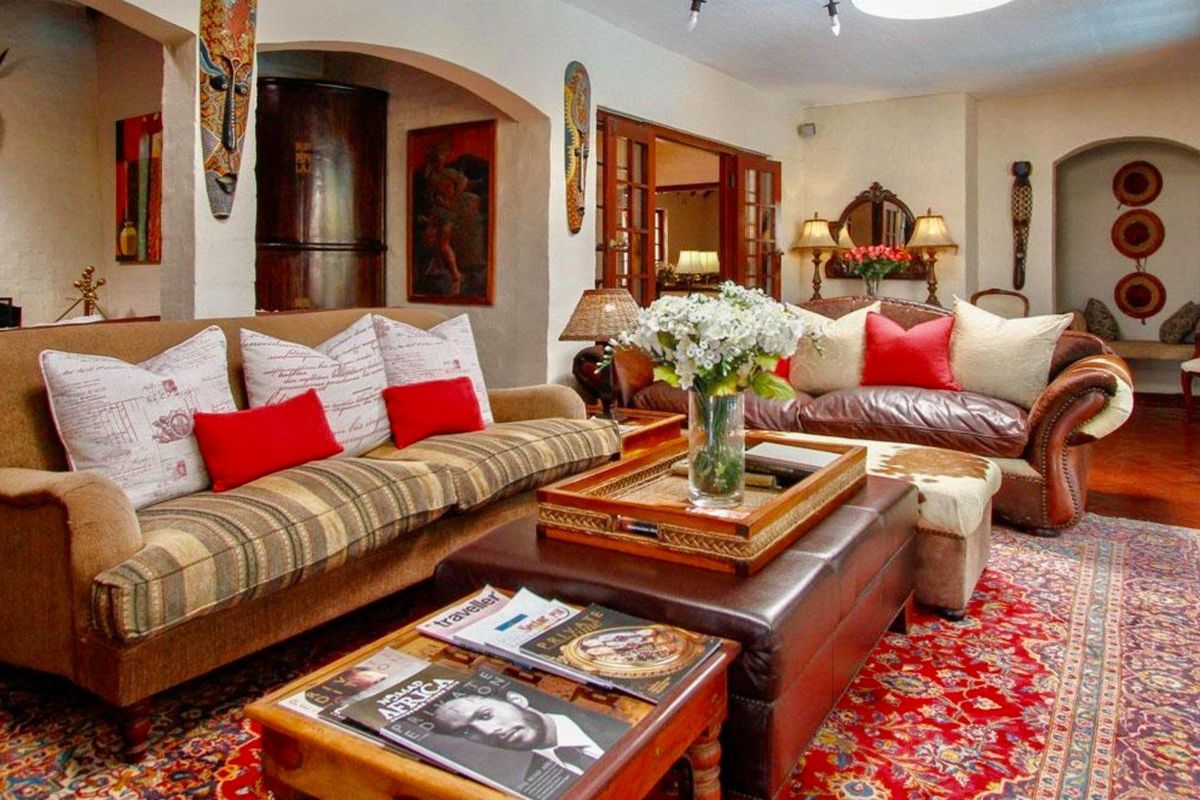 Spacious living room featuring arched architectural openings, tiled flooring, and recessed lighting, creating a warm and inviting atmosphere.