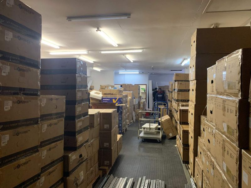 A functional utility or storage space featuring industrial-style rubberized flooring and overhead fluorescent lighting, currently utilized for inventory storage.