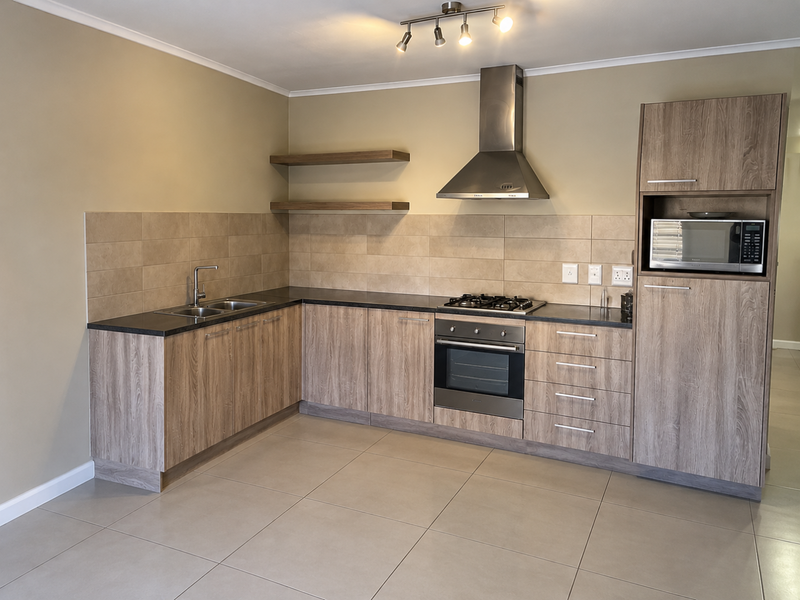 Modern kitchen featuring wood-look laminate cabinetry, stone countertops, built-in gas hob, oven, extractor fan, and integrated microwave with neutral tiled backsplash and flooring.