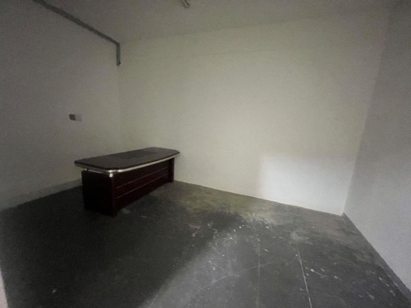 A sparse, unfinished office space featuring bare concrete flooring and exposed wall conduit, suitable for renovation or custom fit-out.