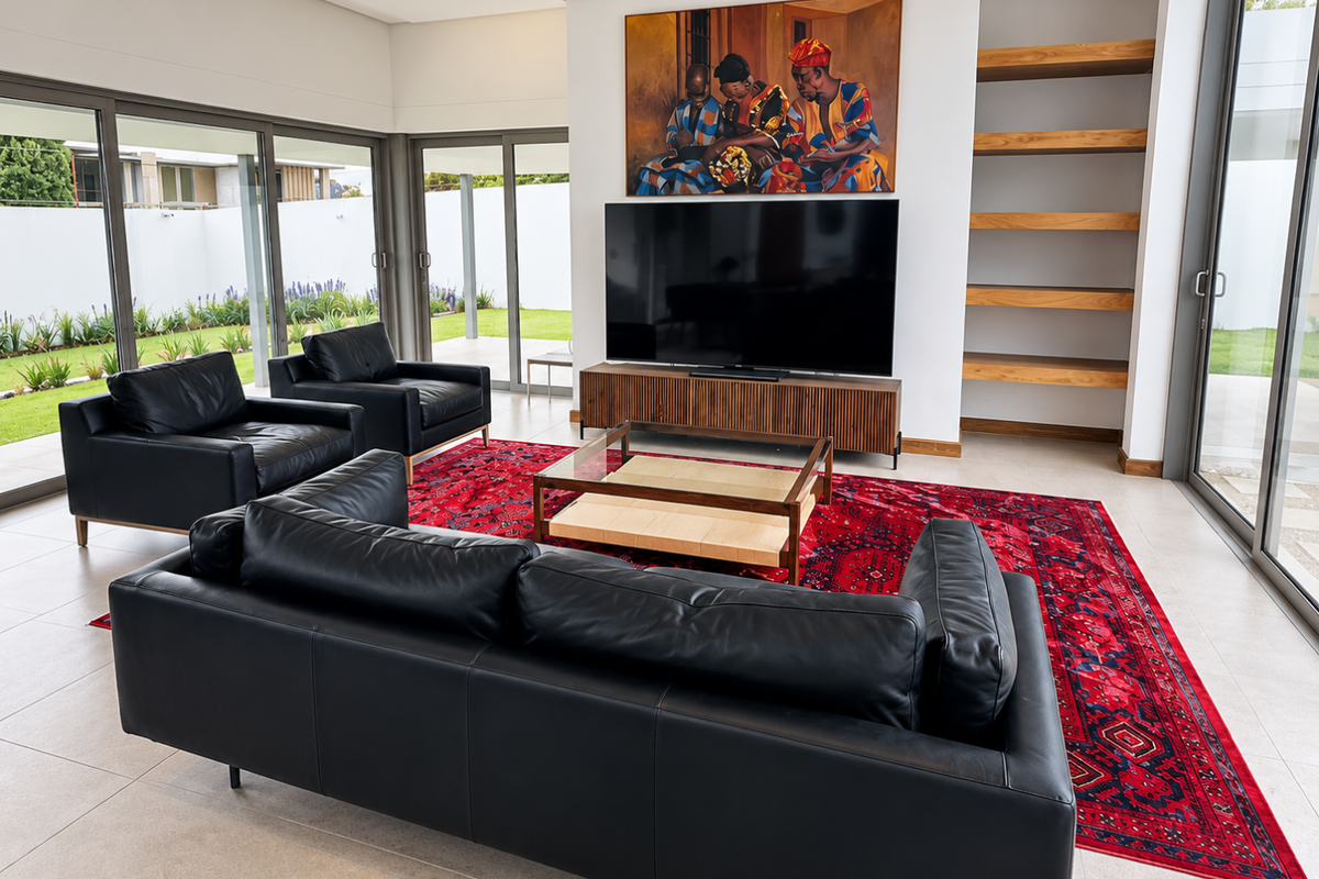 Modern living room featuring large sliding glass doors, built-in timber shelving, and neutral tiled flooring, offering seamless indoor-outdoor flow.