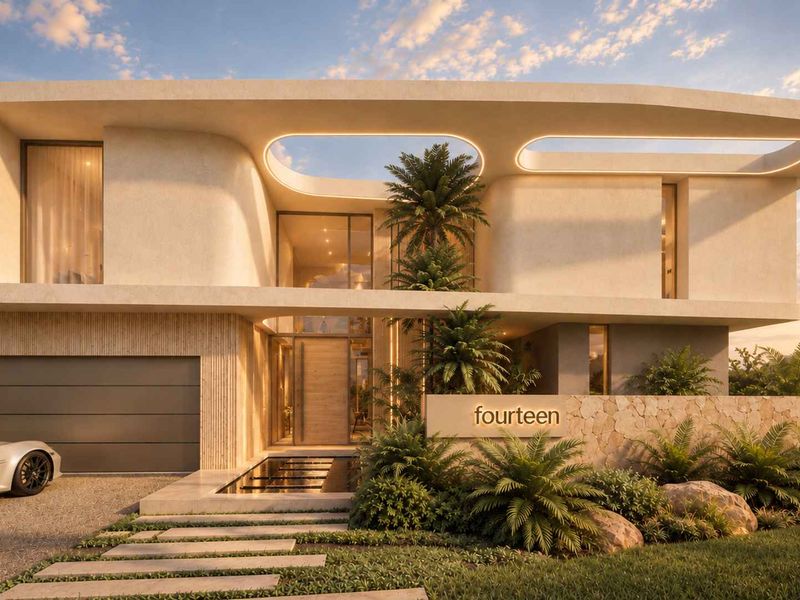 A striking modern architectural facade featuring stone accents, integrated garage, and a sophisticated entrance with a water feature at dusk.