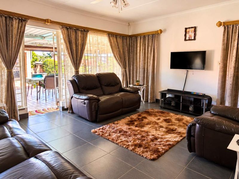 A comfortable living room featuring tiled flooring and large sliding glass doors that provide direct access to the outdoor patio area.
