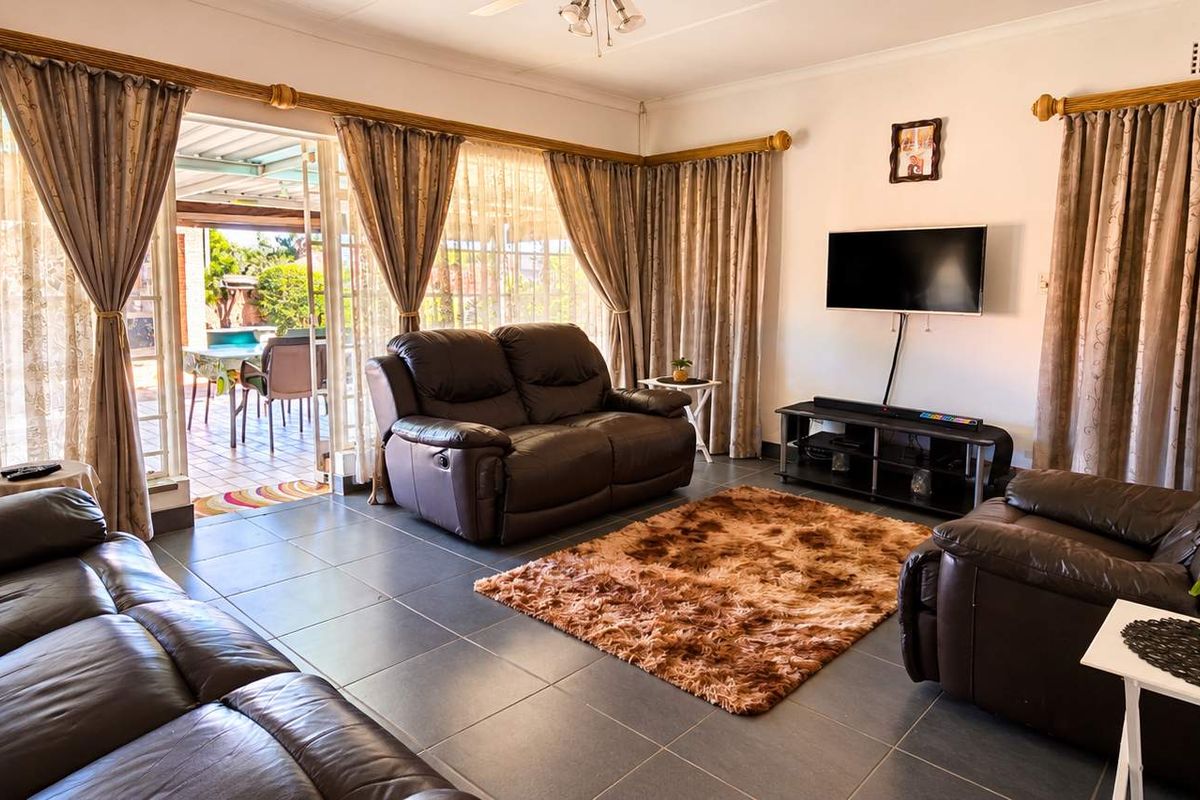 A comfortable living room featuring tiled flooring and large sliding glass doors that provide direct access to the outdoor patio area.
