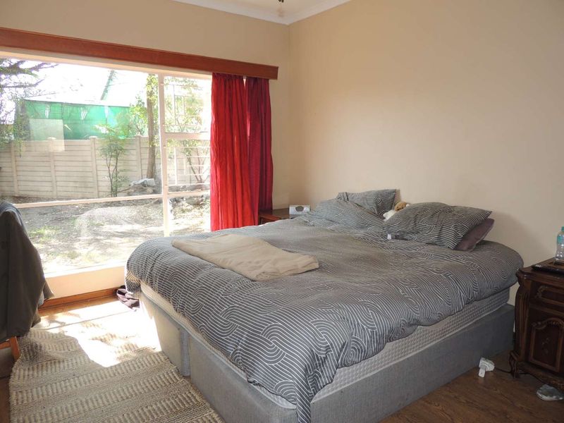 A bedroom featuring laminate flooring and a large sliding glass door that provides natural light and access to the outdoor area.