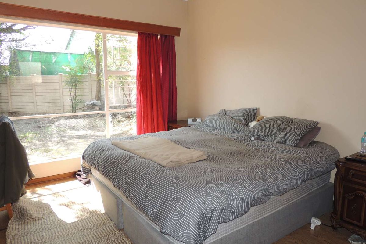 A bedroom featuring laminate flooring and a large sliding glass door that provides natural light and access to the outdoor area.