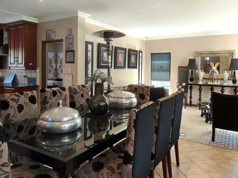 Spacious open-plan living and dining area featuring tiled floors, recessed lighting, and a functional kitchen with built-in cabinetry and appliances.