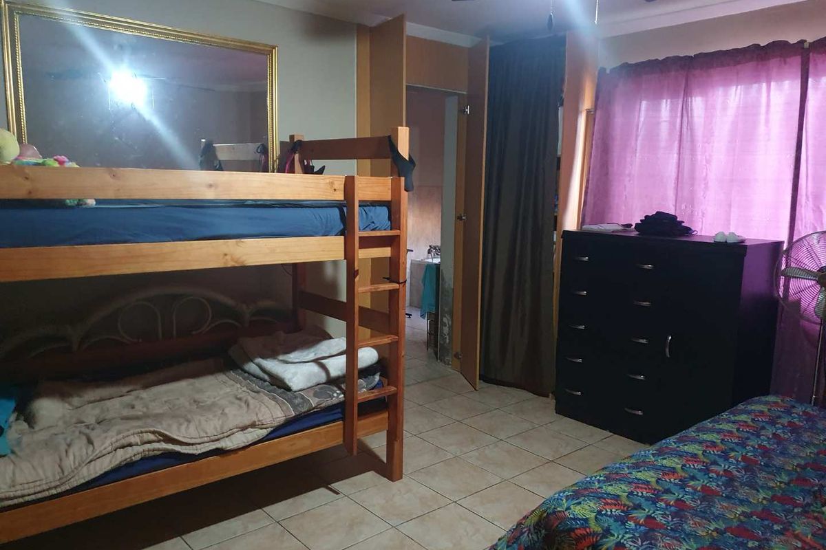 A bedroom featuring tiled flooring, a ceiling fan, and built-in closet space with direct access to an adjacent room.