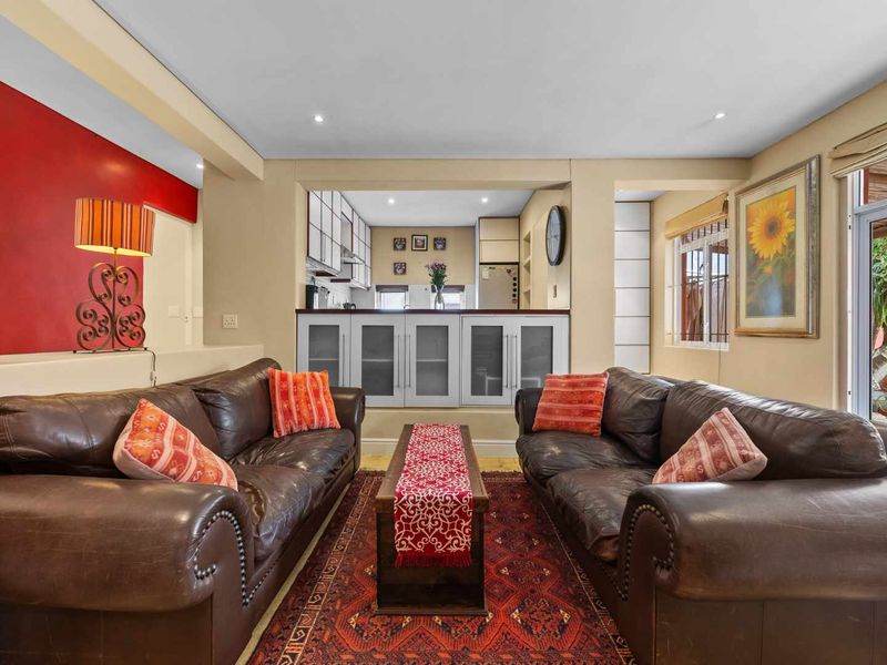 Open plan living area featuring a kitchen pass-through, built-in cabinetry, and direct access to an outdoor space through a sliding glass door.