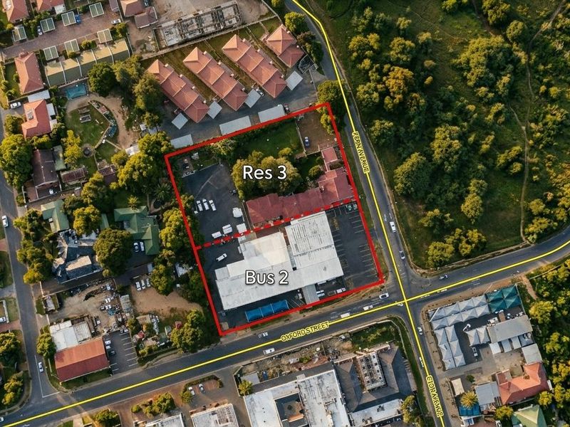 Aerial view of a mixed-use property featuring commercial and residential building structures with associated parking and access roads.
