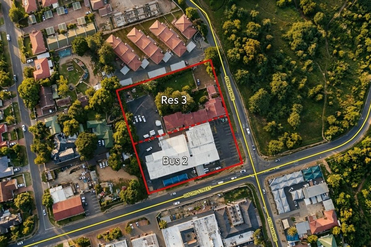 Aerial view of a mixed-use property featuring commercial and residential building structures with associated parking and access roads.