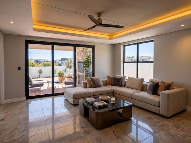 Modern living room featuring polished tiled floors, a recessed ceiling with ambient cove lighting, a ceiling fan, and large sliding doors opening to a patio.
