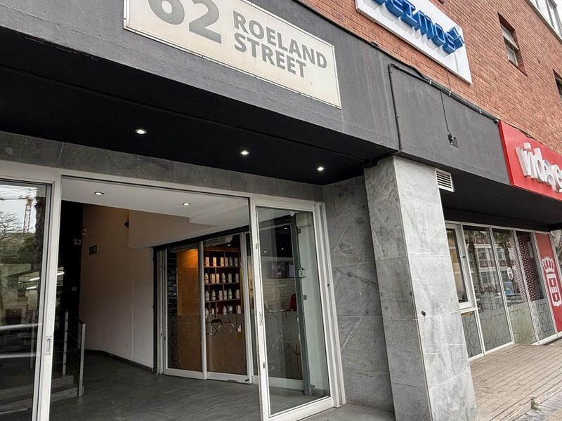 Front entrance of the office building at 62 Roeland Street, featuring modern glass sliding doors, stone cladding, and integrated recessed lighting.