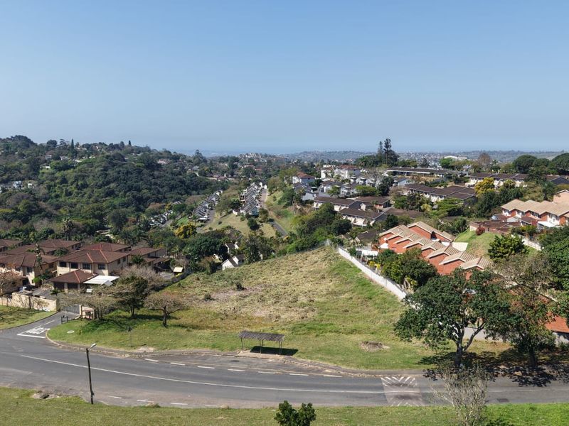 An elevated aerial view of a vacant residential plot situated within an established suburban neighborhood, offering potential for future development.