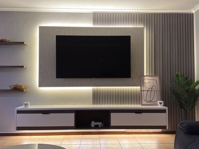 Modern living room featuring a custom built-in media console with integrated LED lighting and stylish slatted wall paneling.