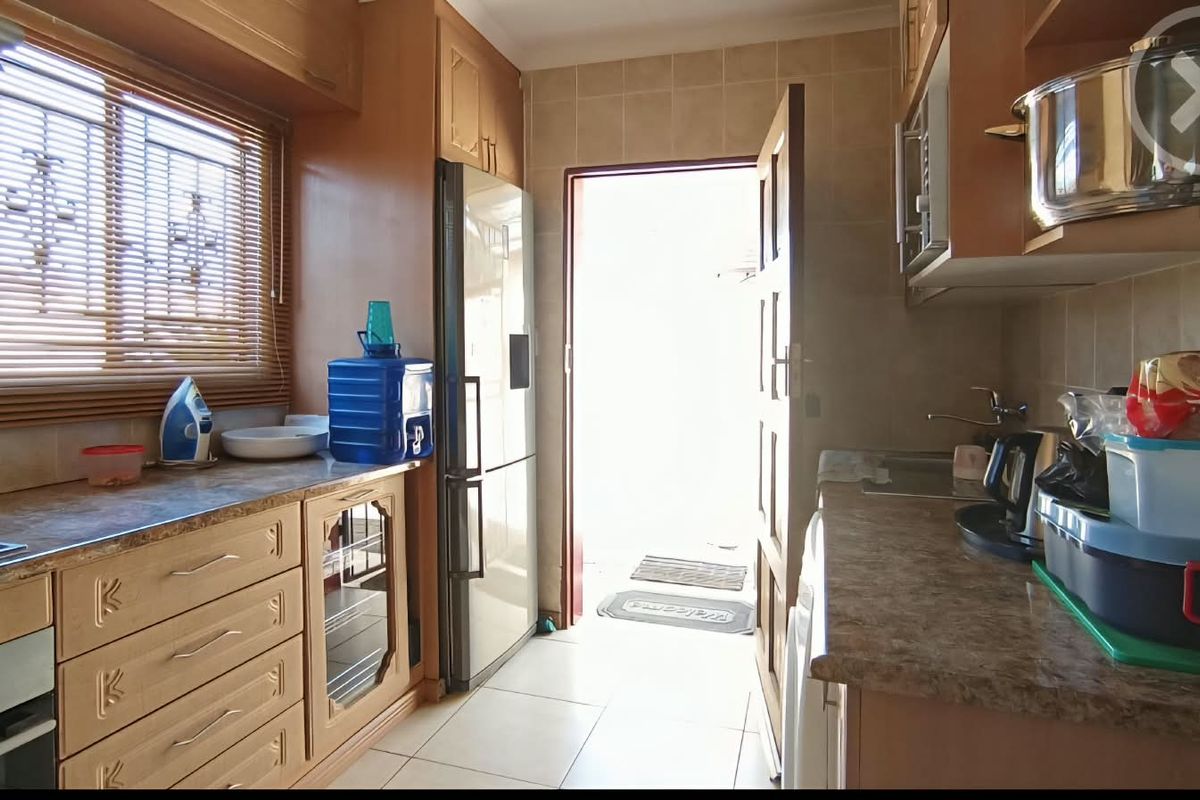 A functional kitchen featuring wooden cabinetry, laminate countertops, built-in oven, and direct access to the exterior.