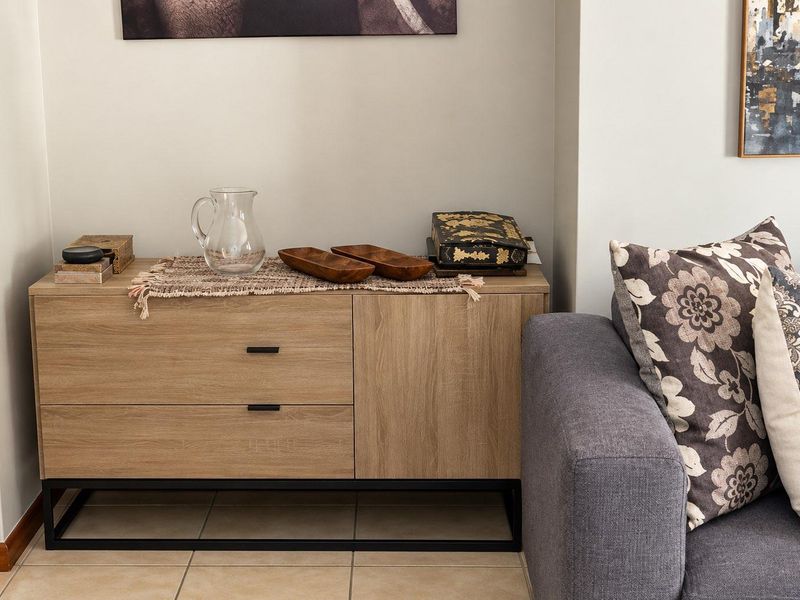A view of a living room area featuring neutral wall tones, tiled flooring, and modern skirting boards.
