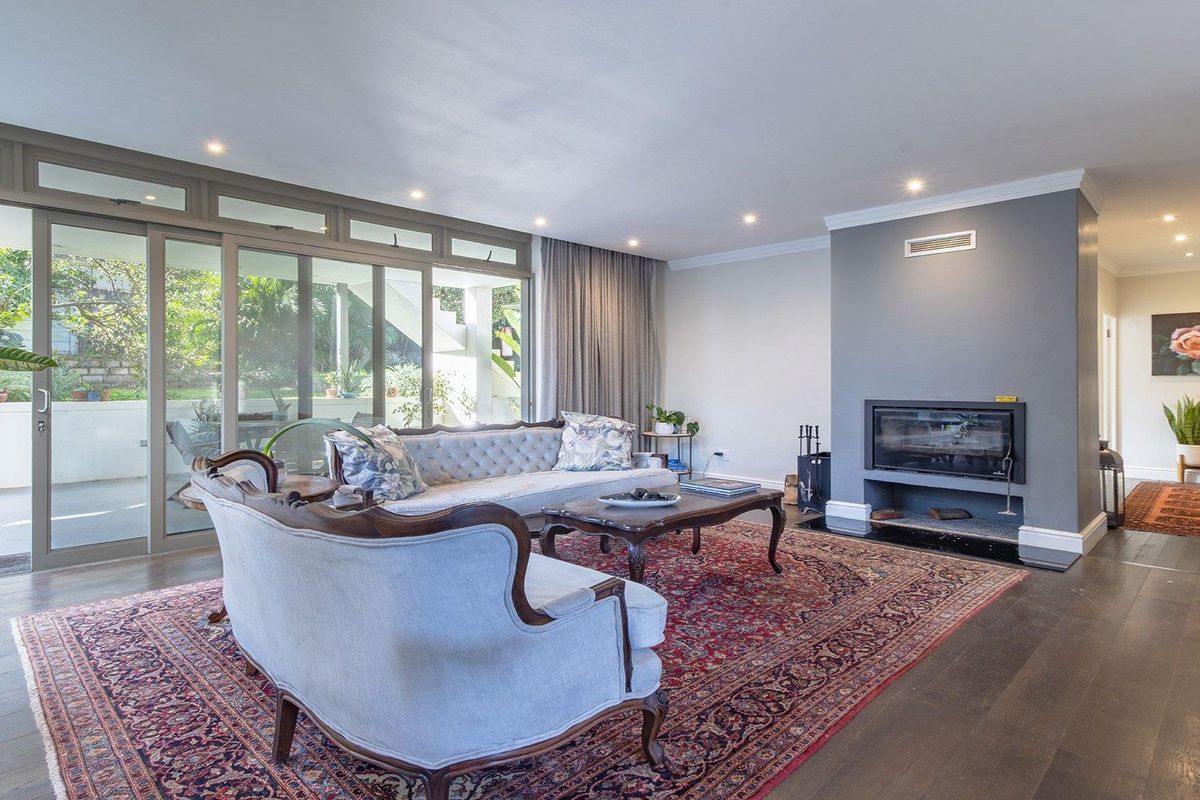 Spacious living room featuring hardwood floors, a built-in fireplace, and large sliding glass doors that provide ample natural light and access to the patio.