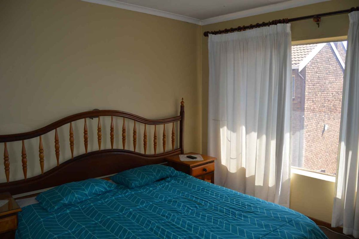 A standard bedroom featuring a window with natural light and neutral wall finishes.